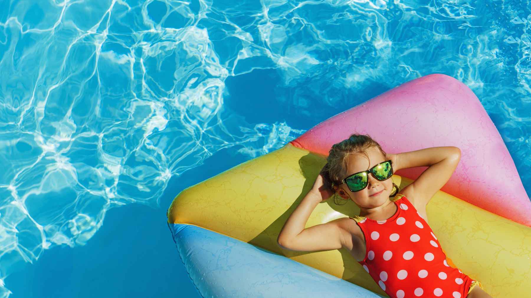 Girl laying on float in vinyl pool