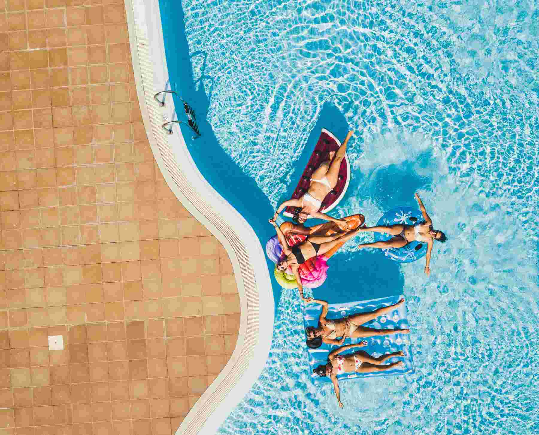 People relaxing on flot in renovated pool
