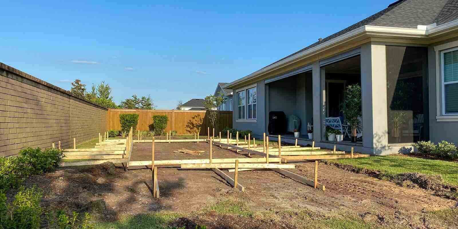 pool being built with the wooden stakes as to where the pool will be located in a backyard