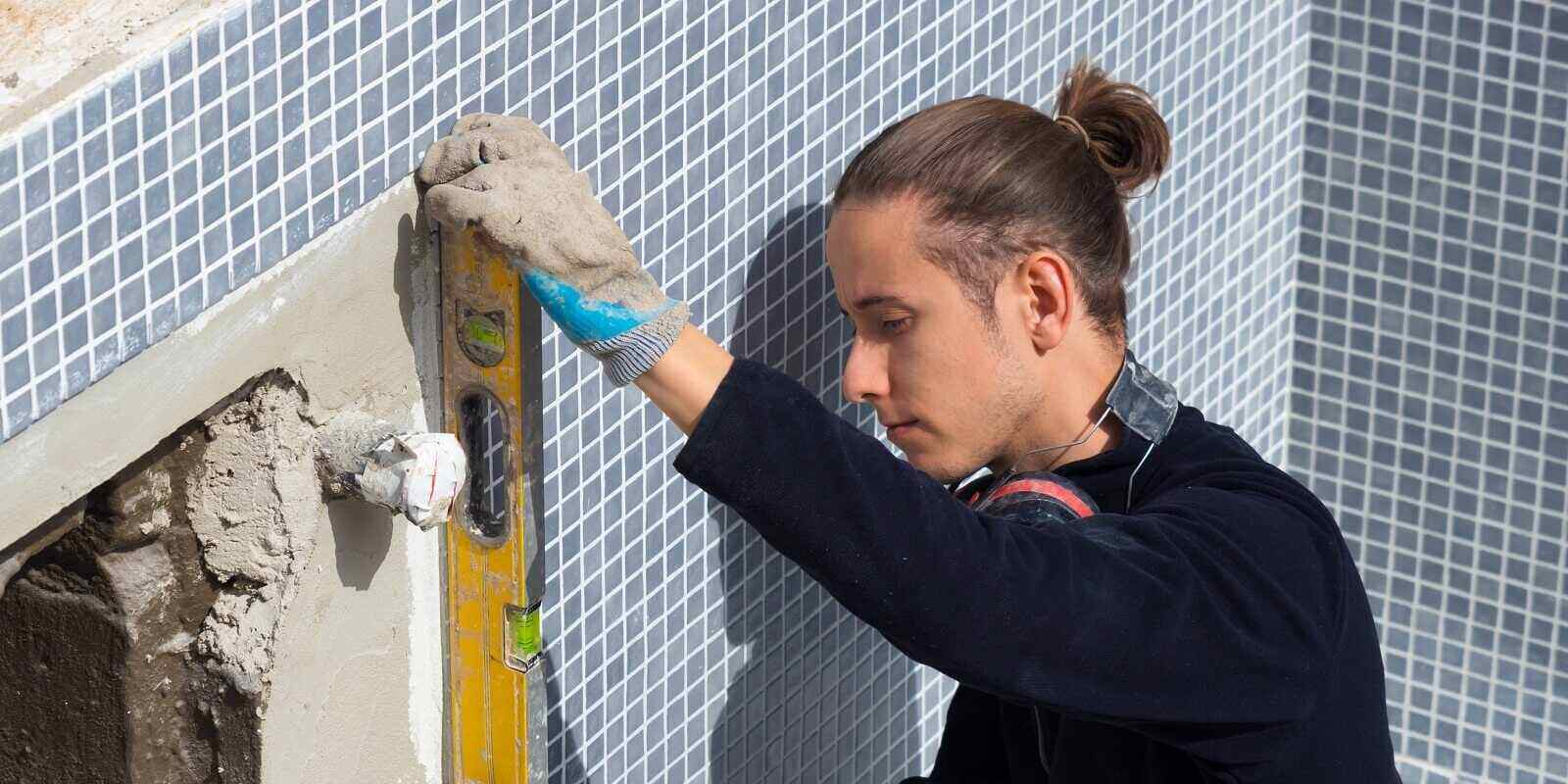 young man leveling his own swimming pool restoration