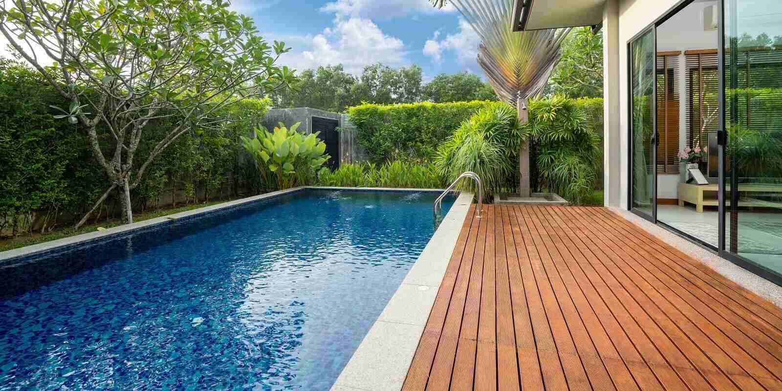 swimming pool and decking in garden of luxury home